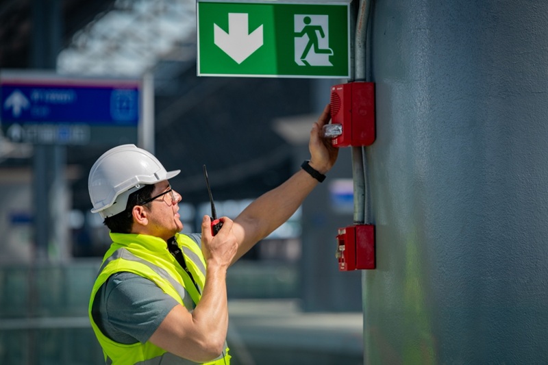 A man inspecting a fire alarm system.