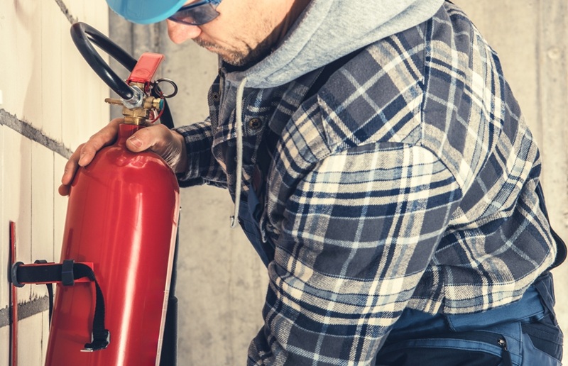 A man grabbing a fire extinguisher.
